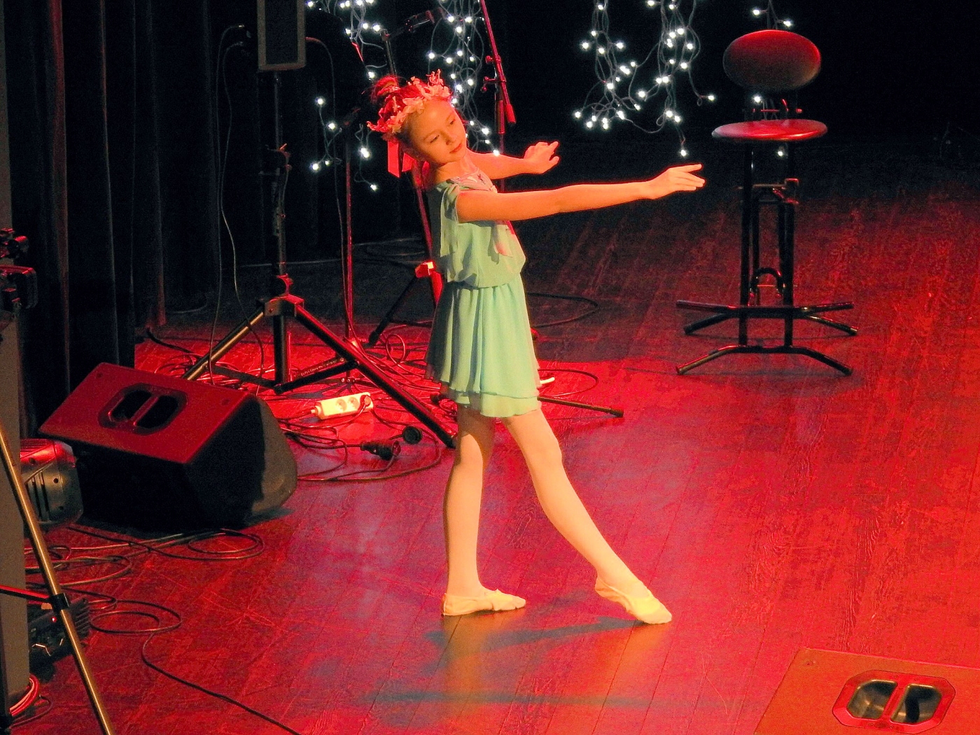 Młoda dziewczynka w stroju baletnicy tańczy na scenie