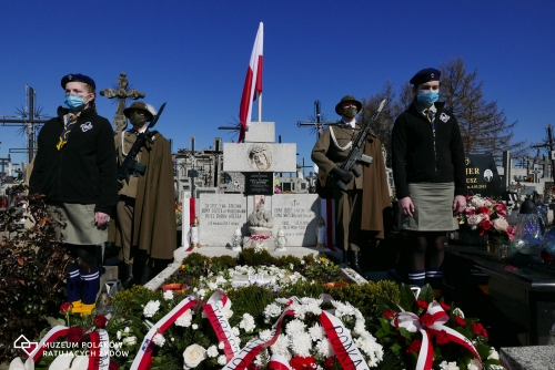 Na zdjęciu widać grób Ulmów na cmentarzu w Markowej, złożone biało czerwone wieńce oraz wartę czyli dwóch żołnierzy oraz dwie harcerki