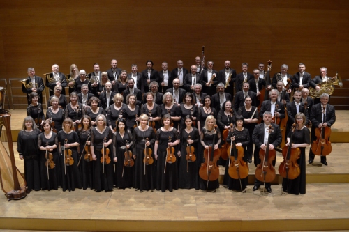 Na scenie filharmonii podkarpackiej stoją ubrani w czarne stroje filharmonicy wraz ze swoimi instrumentami