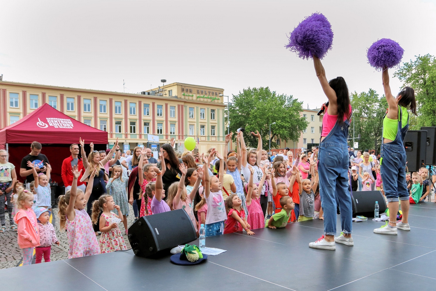 Na scenie animatorki stoją z fioletowymi pomponami pod sceną stoją dzieci