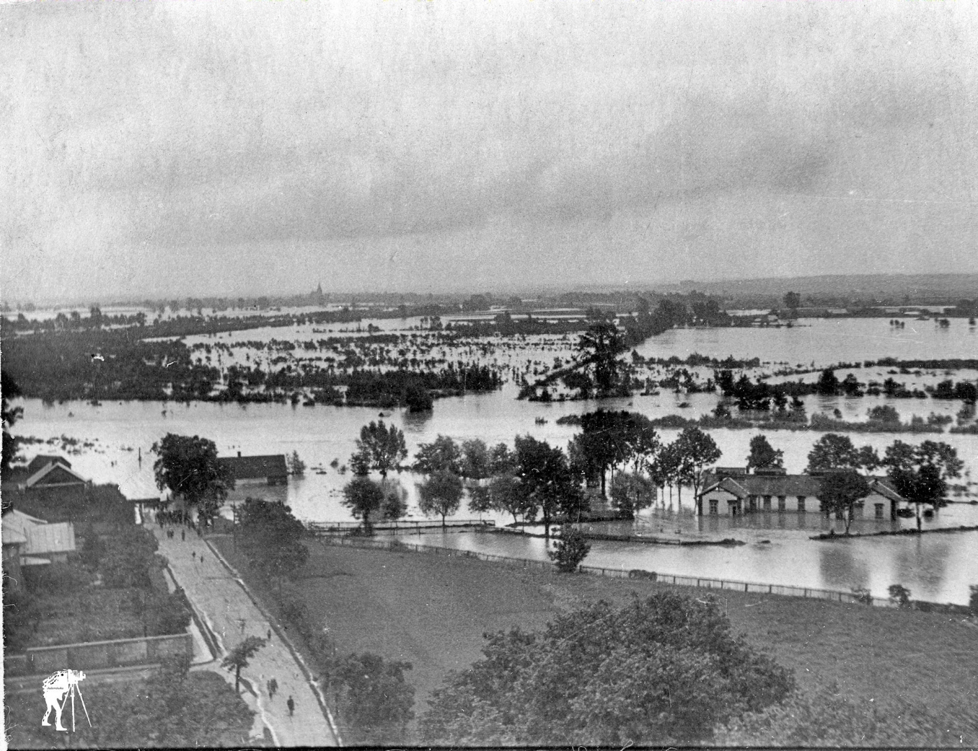 Archiwalne zdjęcie czarno-białe z powodzi porzedstawia pozalewane domy, pola