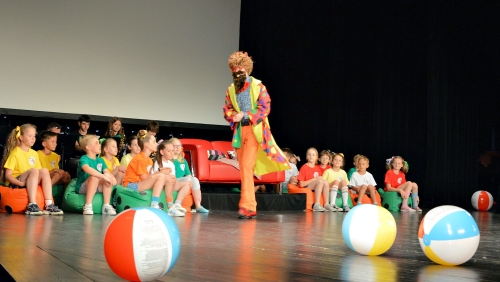 Te same dzieci ale dodatkowo na scenie jest Pan Kleks z brodą i kolorowe duże piłki