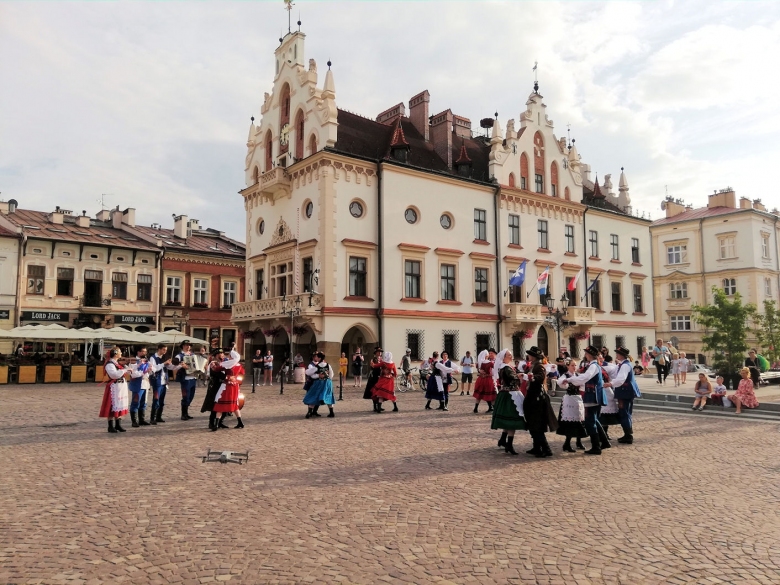Zespół Bandoska w strojach ludowych tańczy na płycie Rynku Rzeszowskiego przed ratuszem