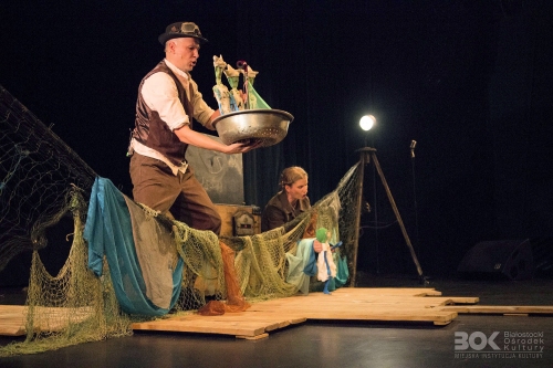 Scena teatralna rekwizyty: sieć rybacka oraz aktorzy animujący lalki