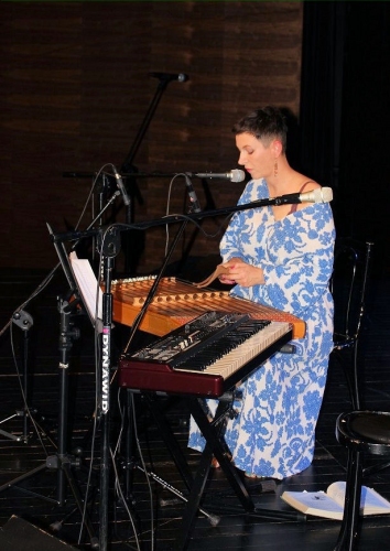Ania Brody na scenie przed nią instrument klawiszowy i cymbały na których gra