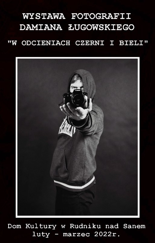 Czarno-białe zdjęcie. Mężczyzna ubrany w bluzę z kapturem na wyciągniętej ręce trzyma aparat i robi sobie zdjęcie.