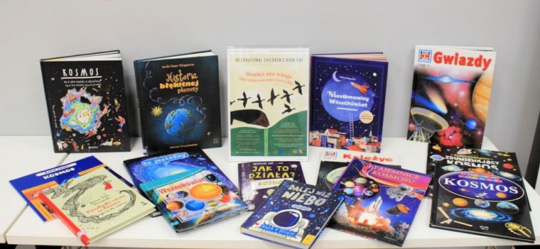 Na stoliku kilka wyłożonych książek dla dzieci o kosmosie