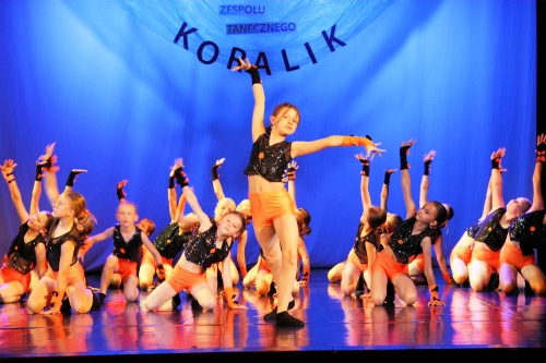 Młodsze dziewczyny z zespołu koralik tańczą na scenie