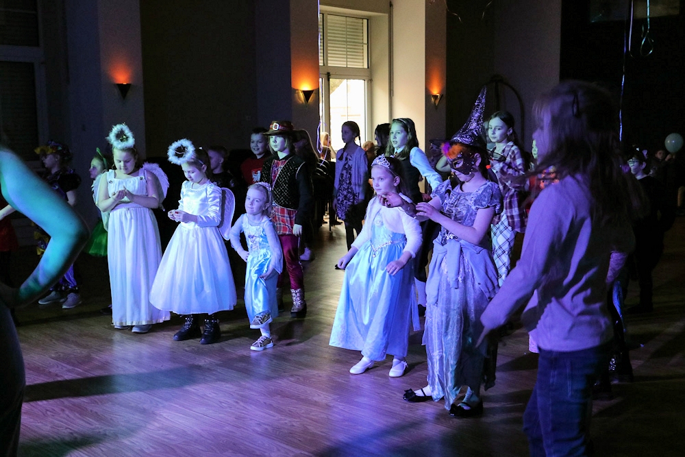 Zabawa taneczna dzieci przebrane w różne stroje tańczą na sali