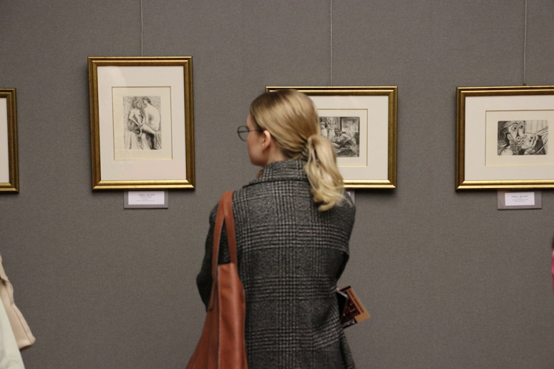 Na ścianie galerii widać grafiki Picassa i osobę, która je ogląda